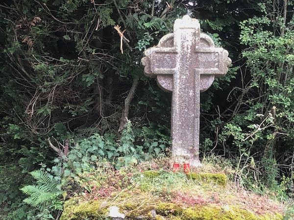 Stone cross on a grassy knoll, commemorating the dead of the Great Famine